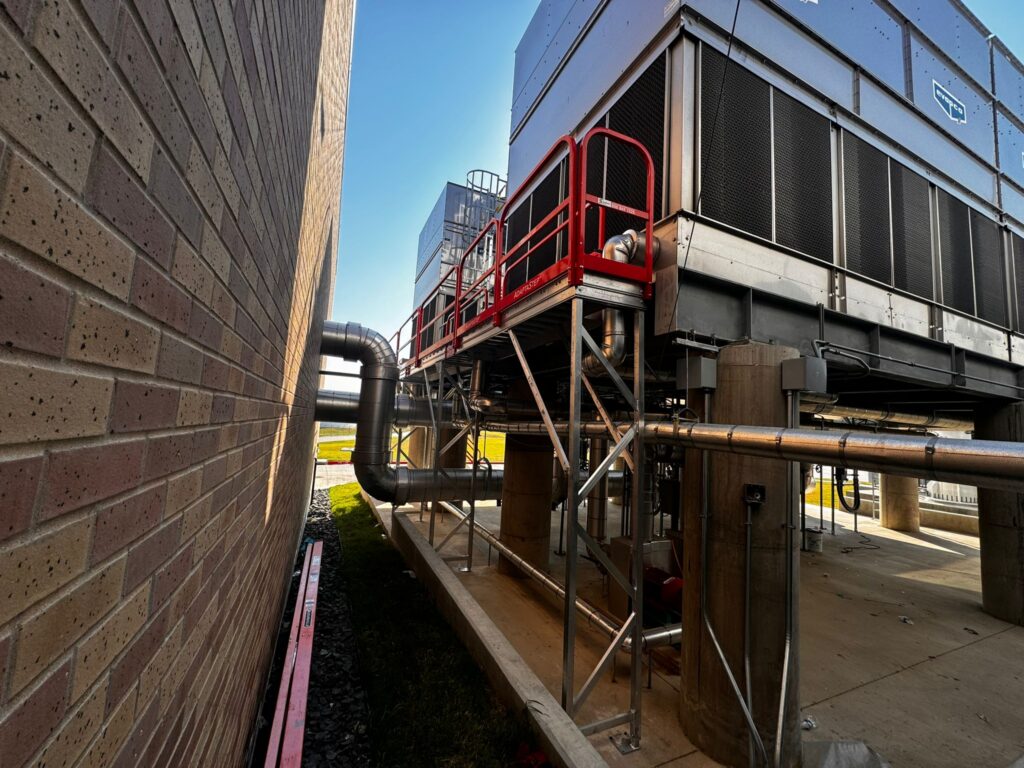 AdaptaStep maintenance platform and stairs beside an industrial structure.